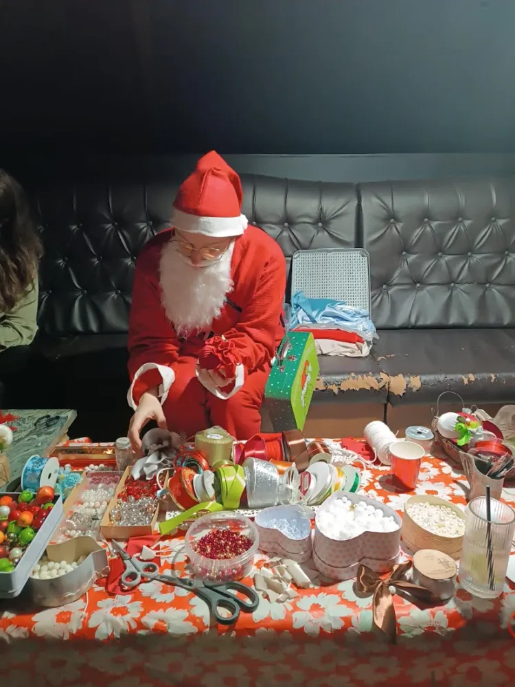 Kalėdų senelis kuria žaisliuką įmonės šventėje